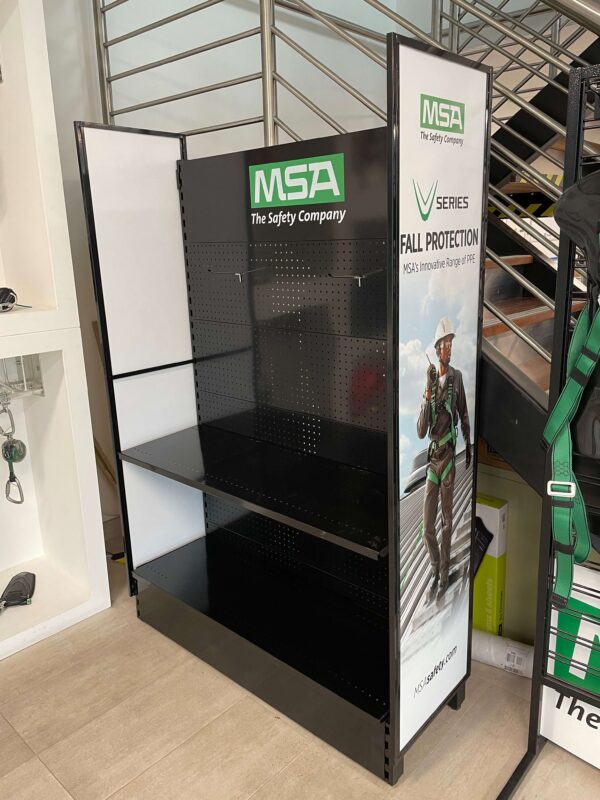 black and white shelving bay with custom green and white logo placement sitting on a concrete floor at the base of stairs.