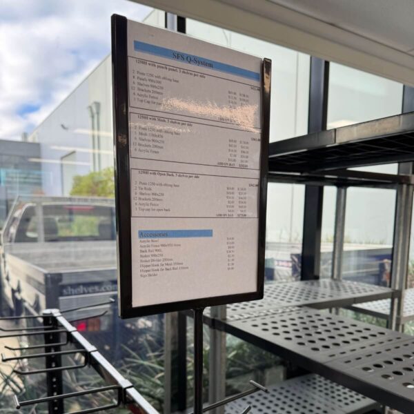 black frame A4 sign holder sitting on black shelving unit